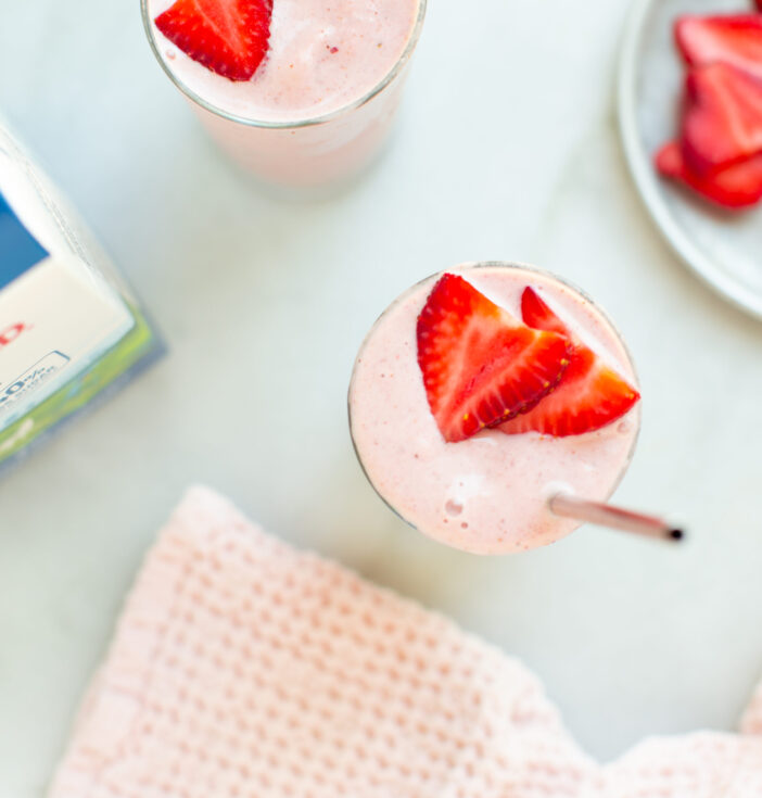 Two strawberry banana smoothies with a bottle of Darigold FIT milk