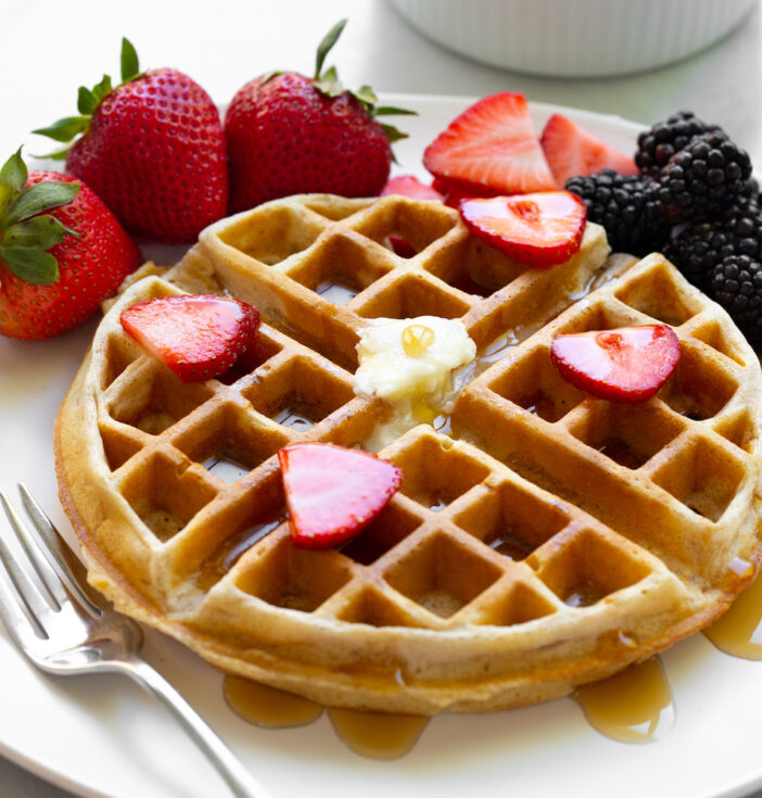 Belgian waffle with fruit on a white plate