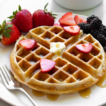 Belgian waffle with fruit on a white plate